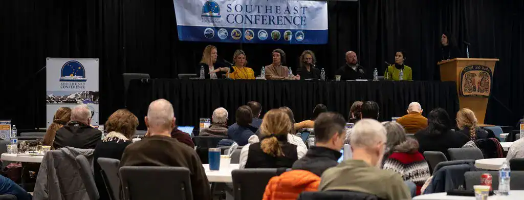A group of people sitting at tables in a large room.